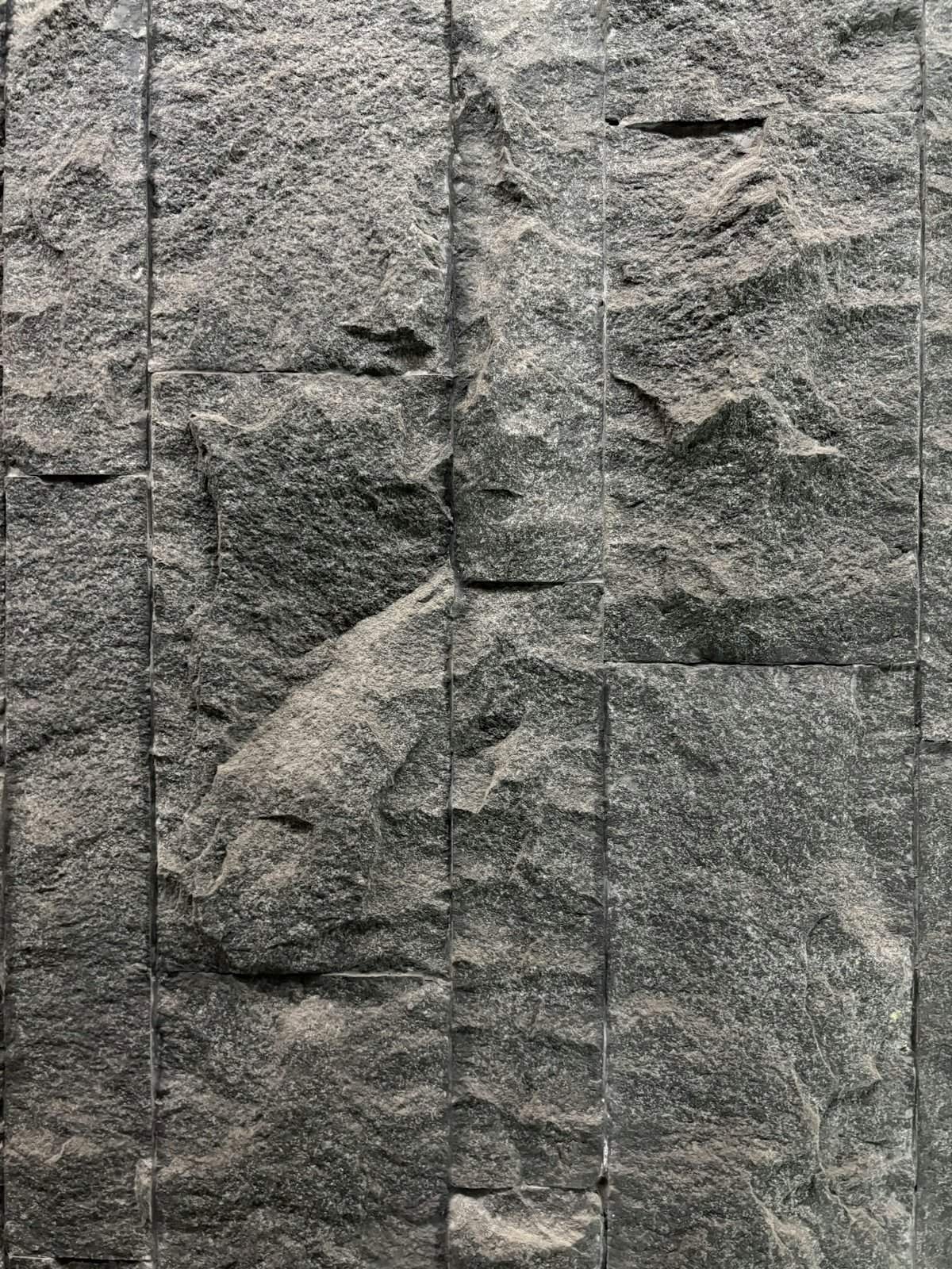Dark grey granite wall with vertical tiles
